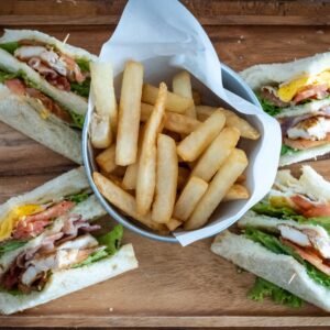 club sandwich cut in 4 pieces and arranged around a cup of french fries