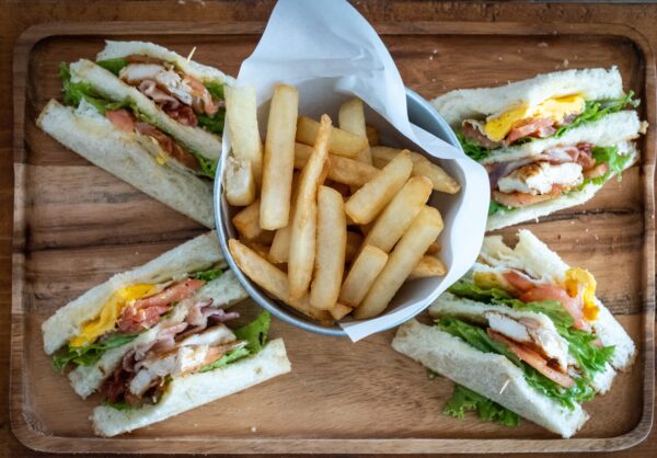 club sandwich cut in 4 pieces and arranged around a cup of french fries